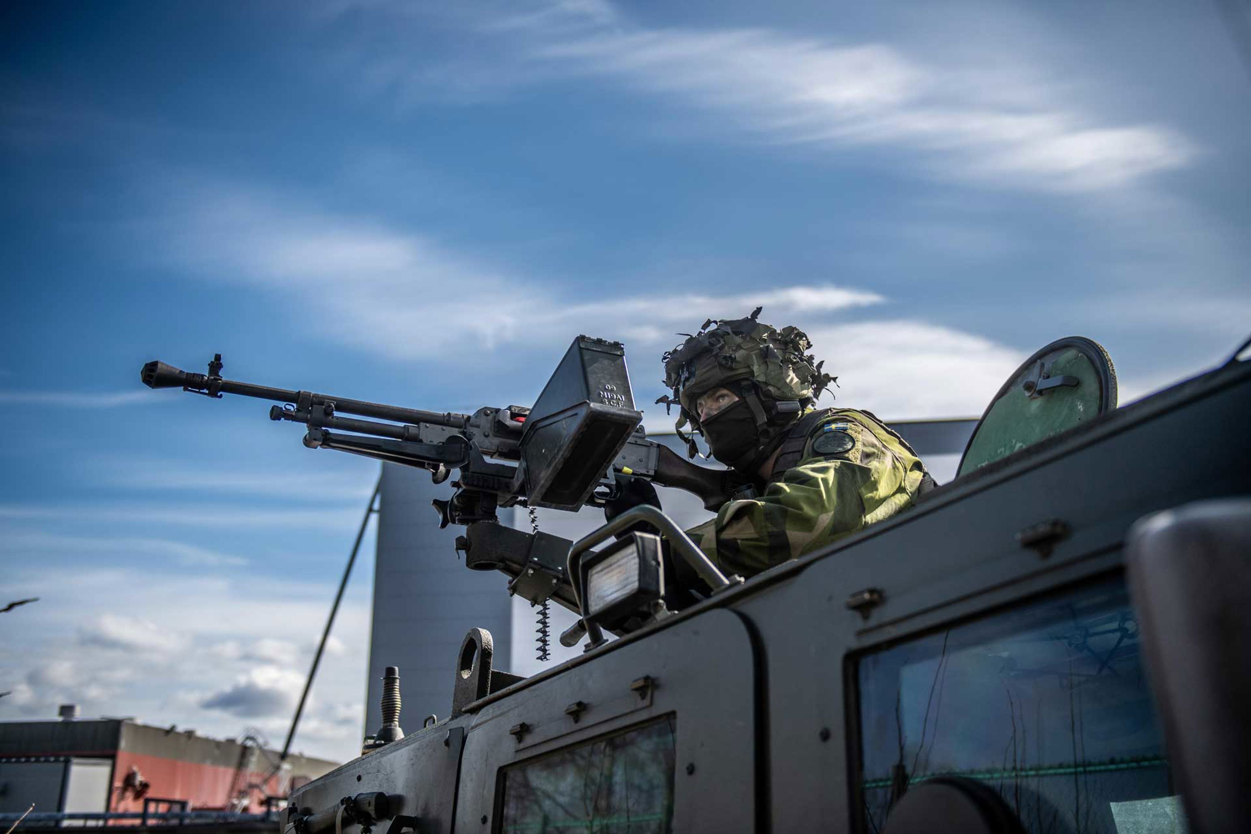 Soldat med maskingevär på taket av ett fordon