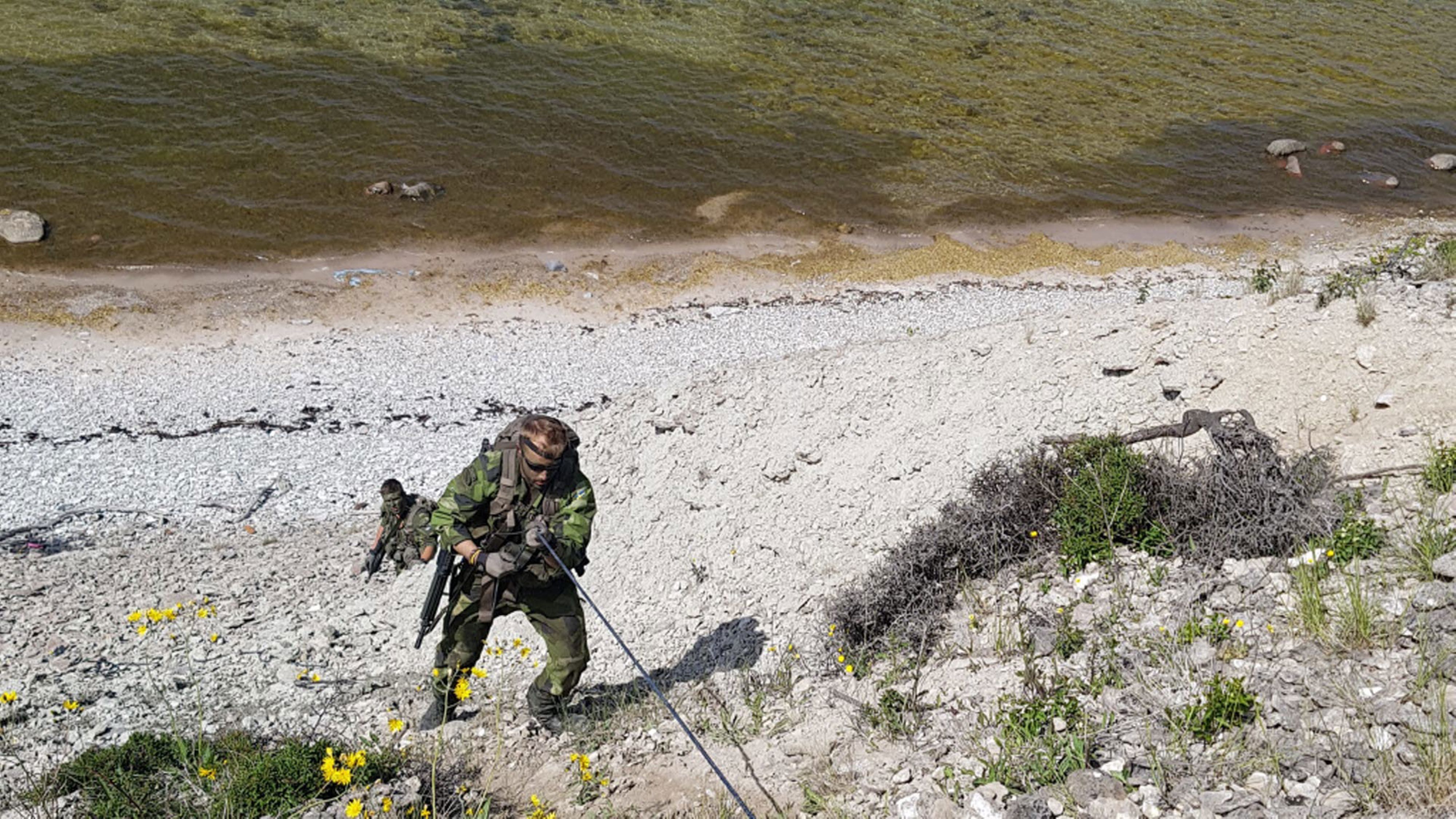 Soldater från P 18 tar sig förbi hinder i terrängen.