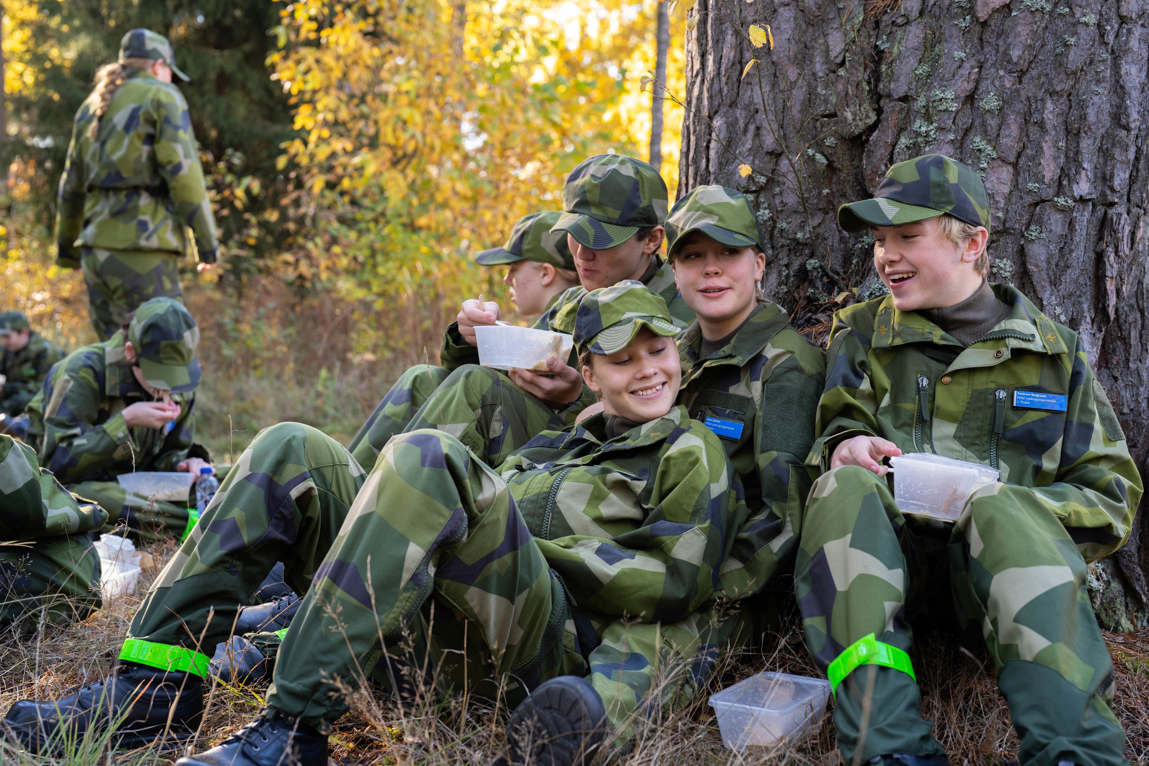 Glada Prao-elever i militär uniform äter lunch.