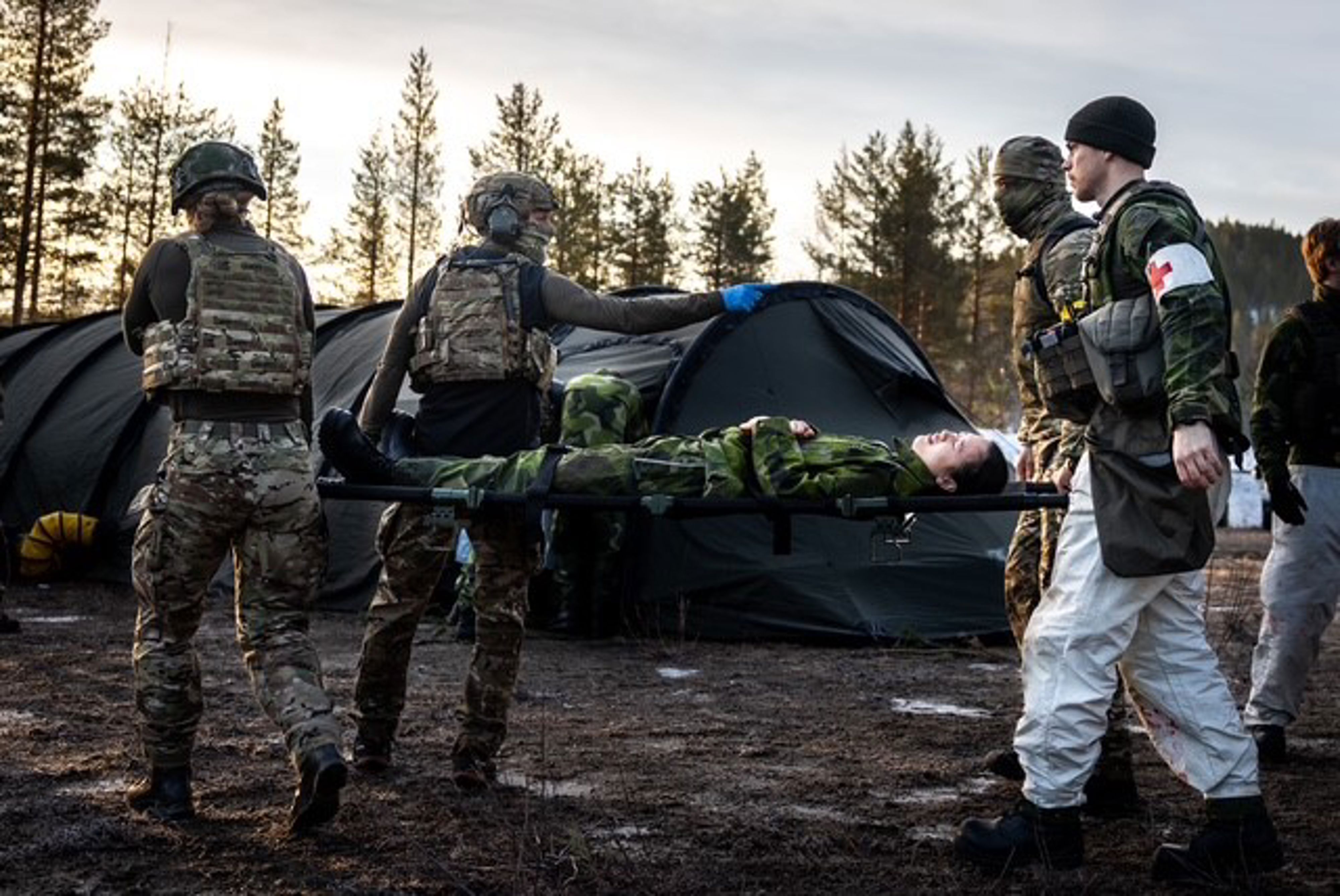 Sjukvårdare bär person på bår.