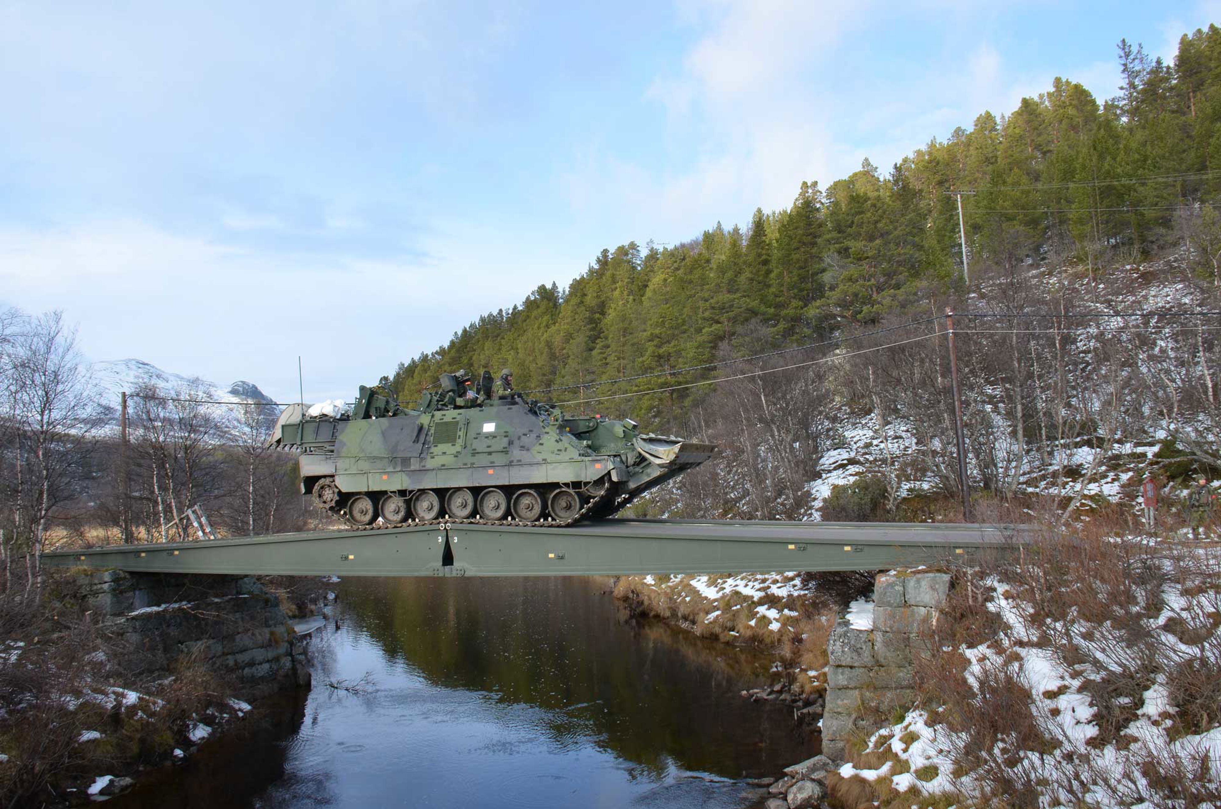 Ingenjörbandvagn som kör över en bro.