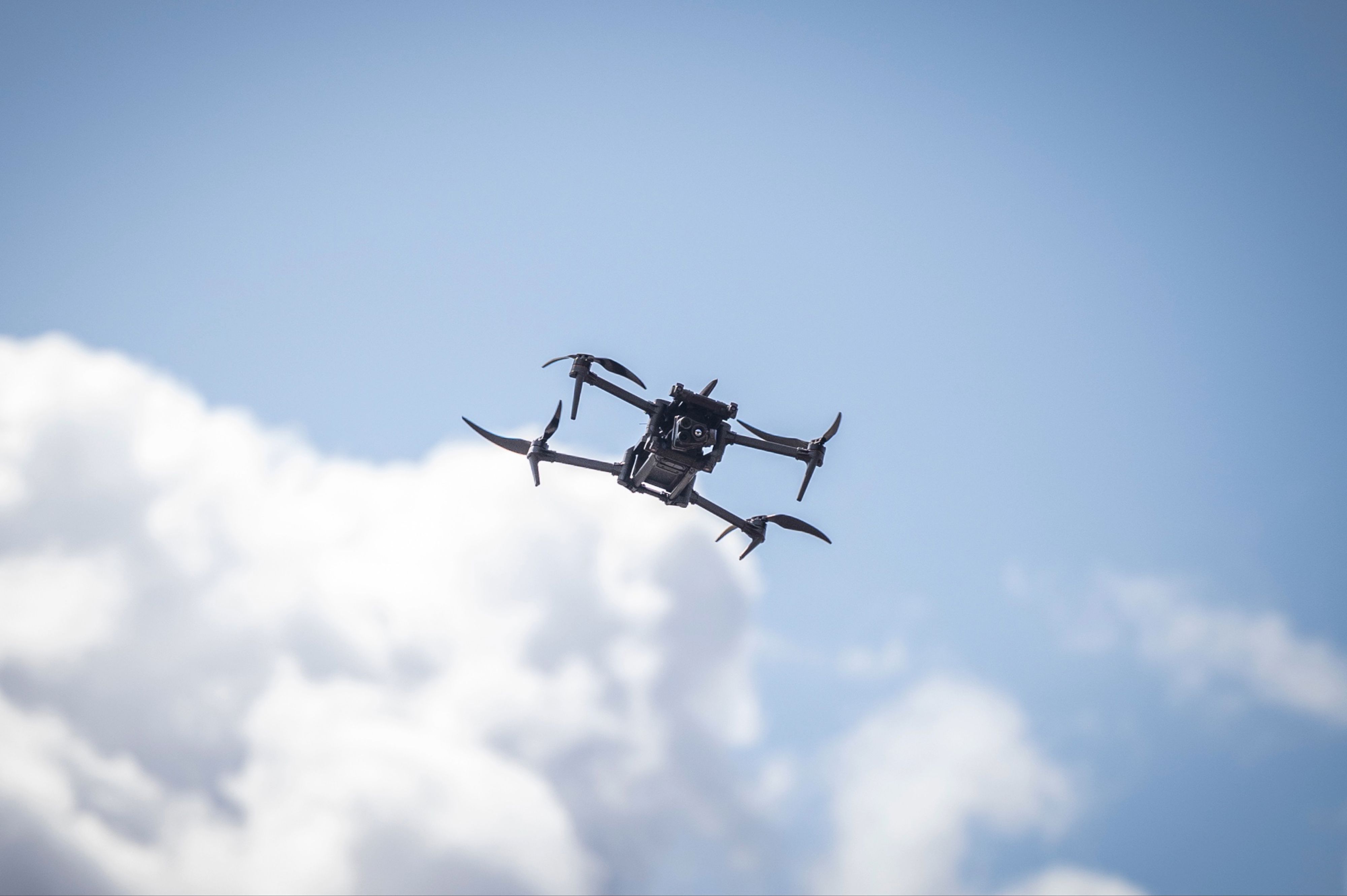 Drönare i luften med operatör från Försvarsmaktens UAS-centrum.