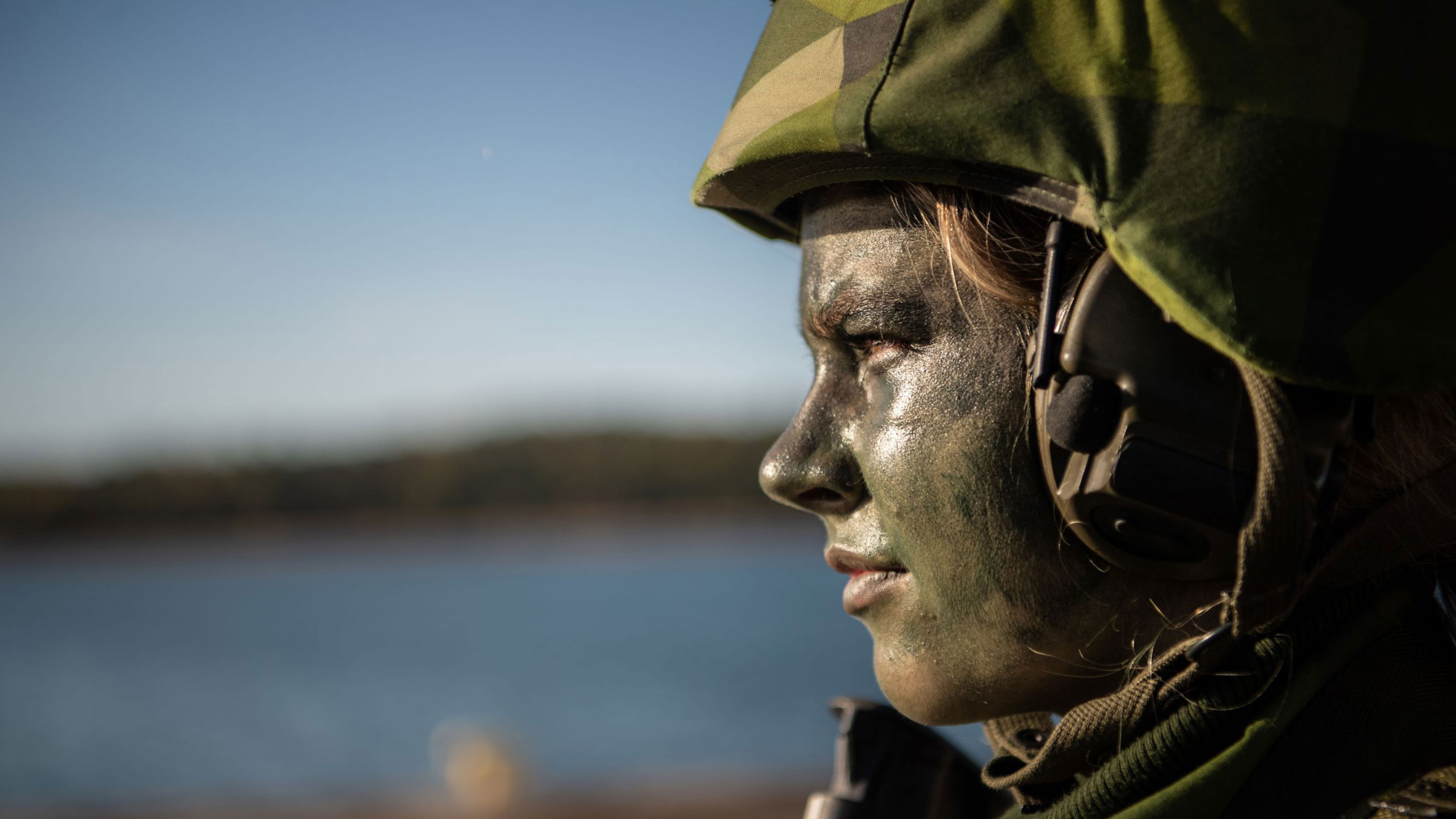 Närbild på soldat som står och blickar ut över vatten.
