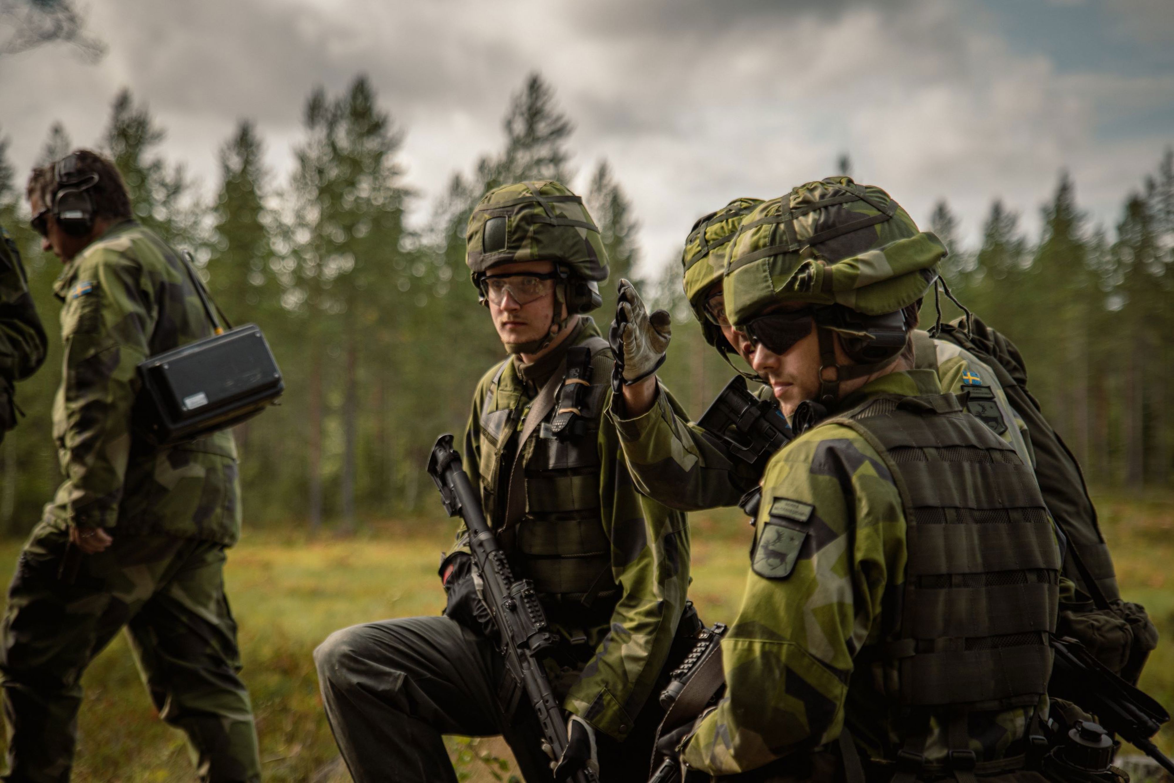 Soldater i fält. En soldat pekar ut en riktning.