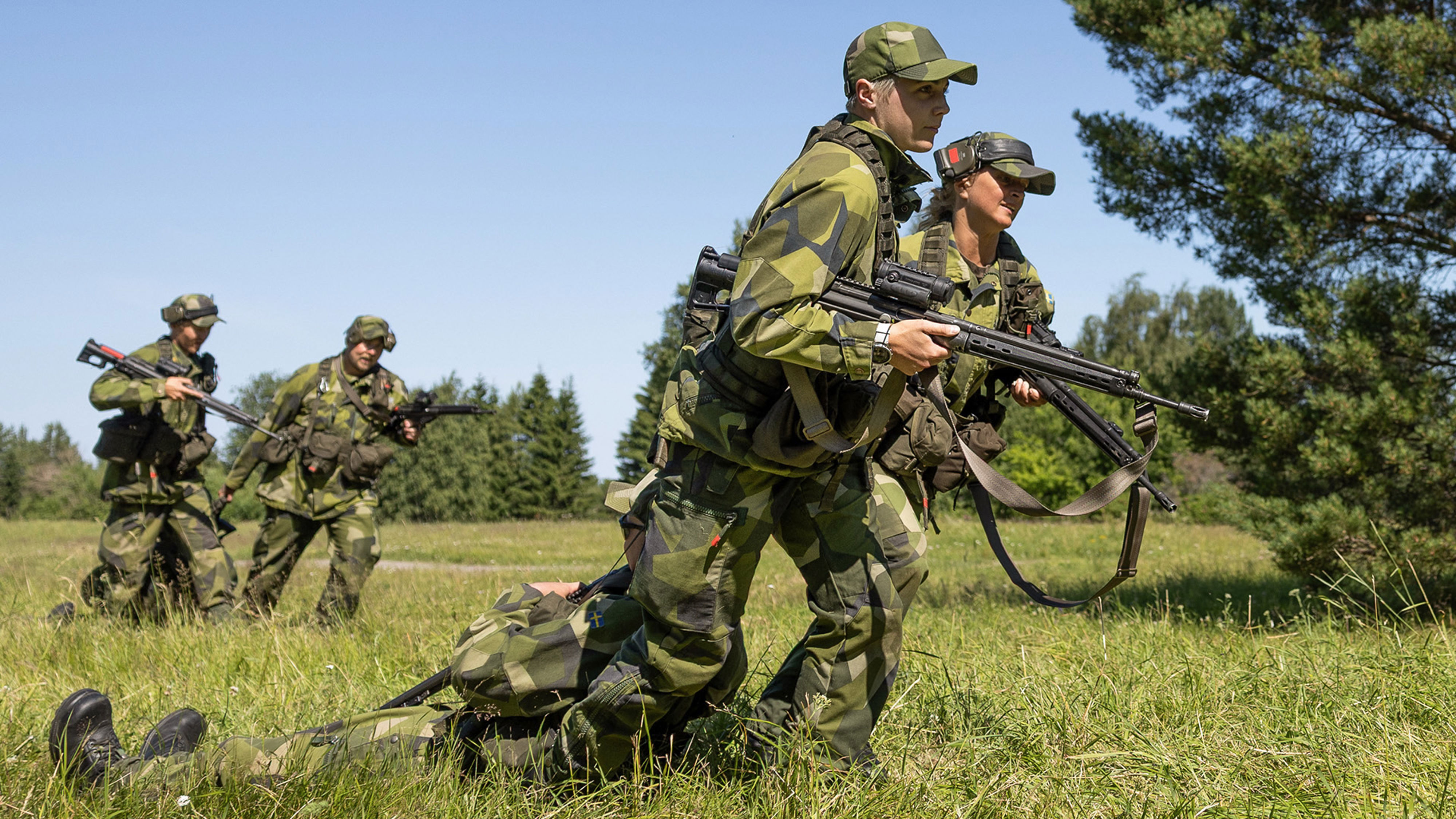 Soldater drar en annan soldat över ett fält.