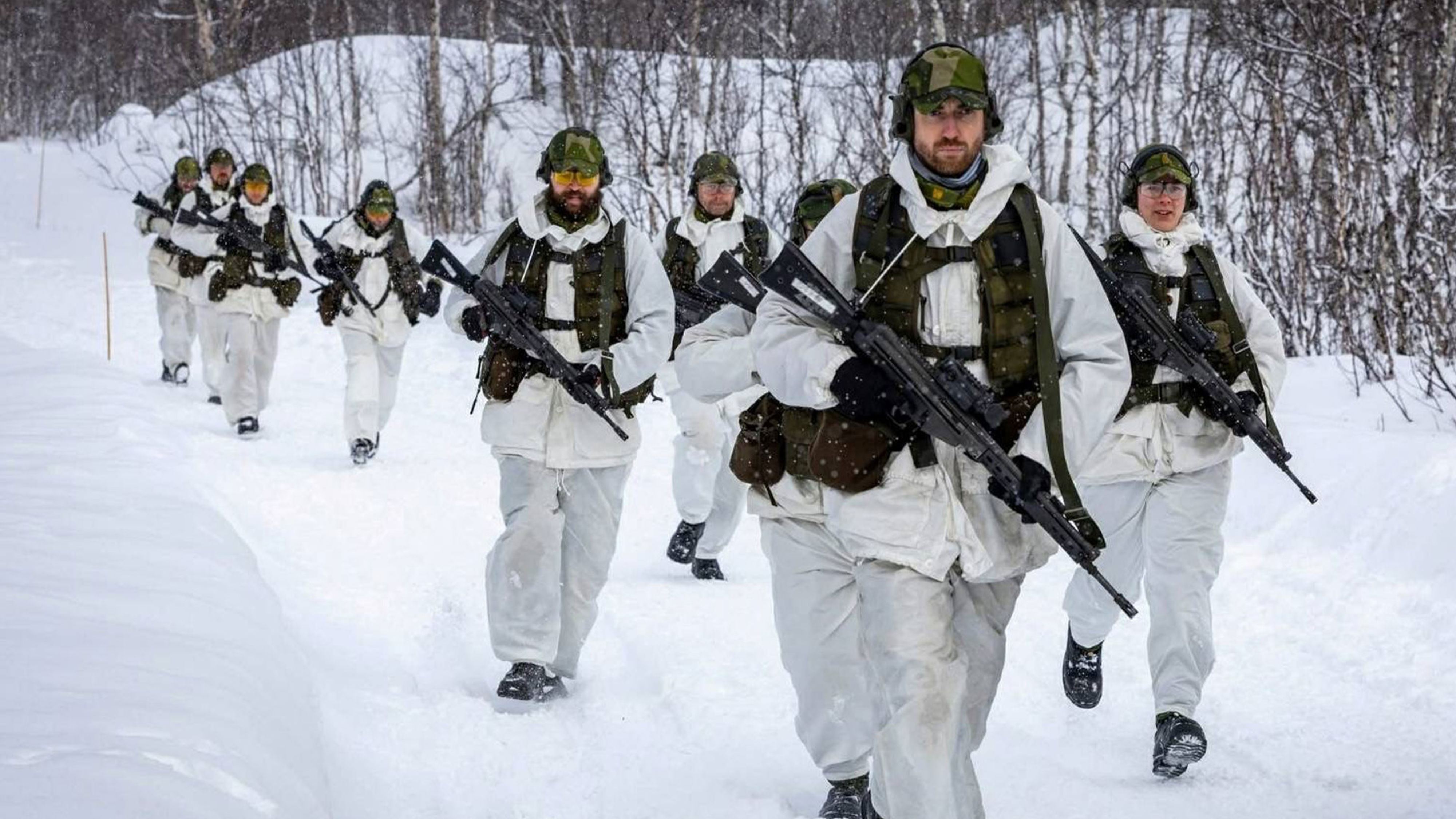 Soldat går på en väg i vintermiljö.