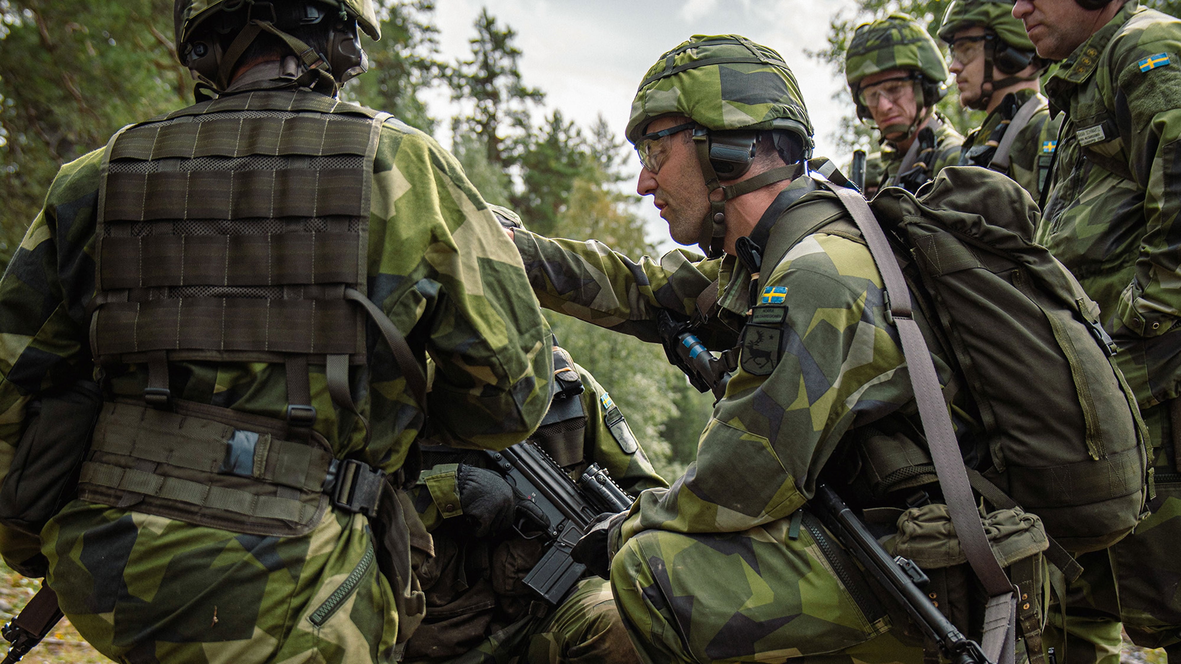 Soldat står samlade och kollar på en karta.