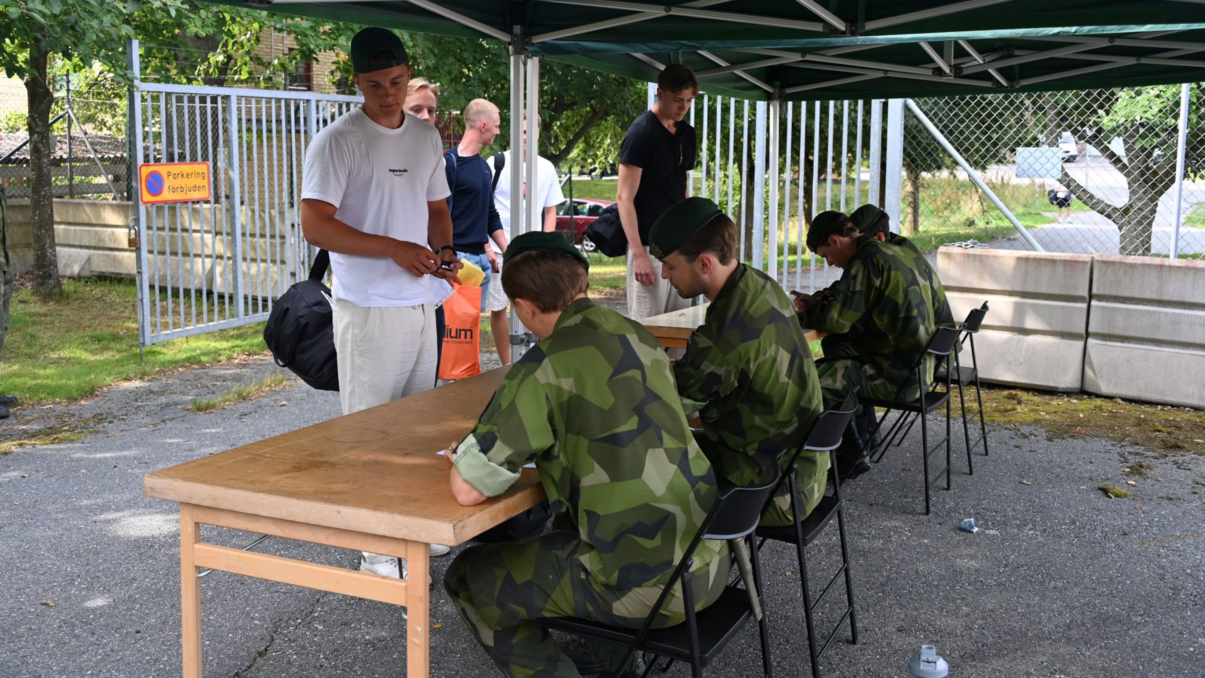 Ett par militärer som sitter vid ett bord med några civila