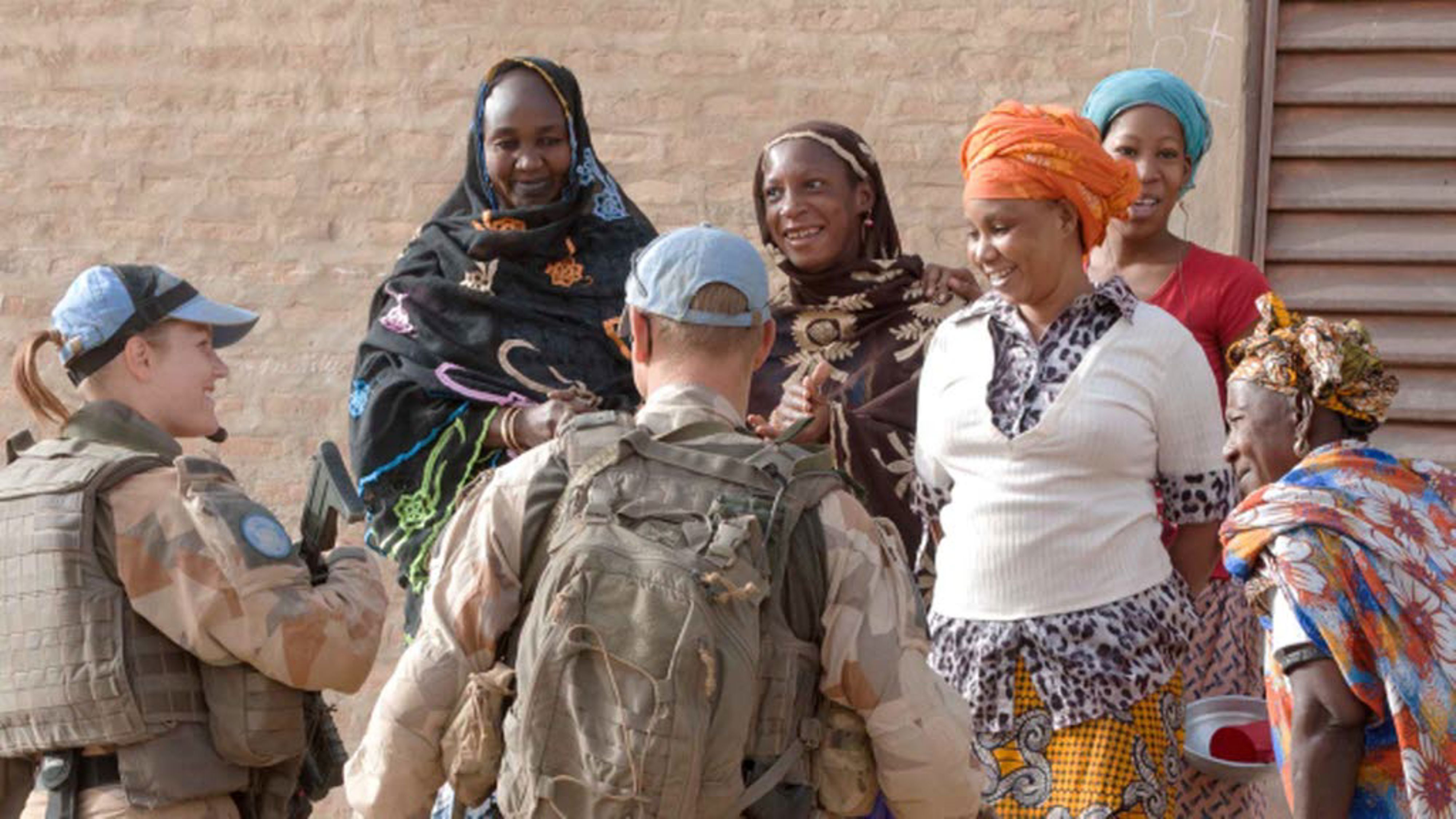 Två militärtolkar pratar med tre kvinnor.