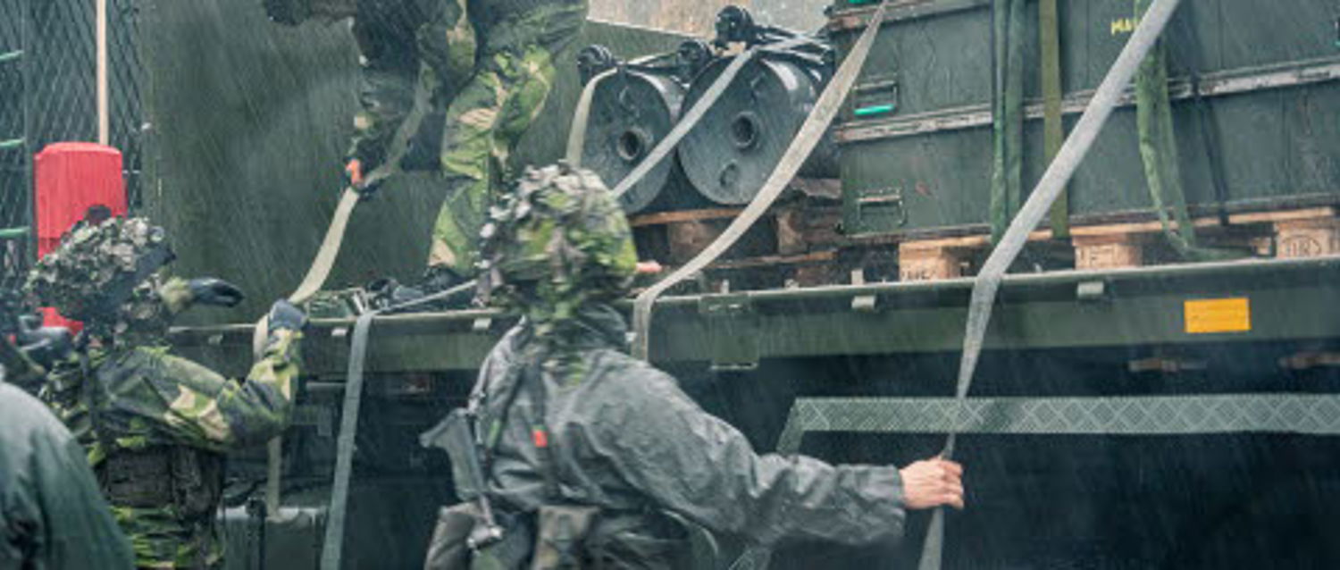 Militärer drar i rep vid ett fordon.