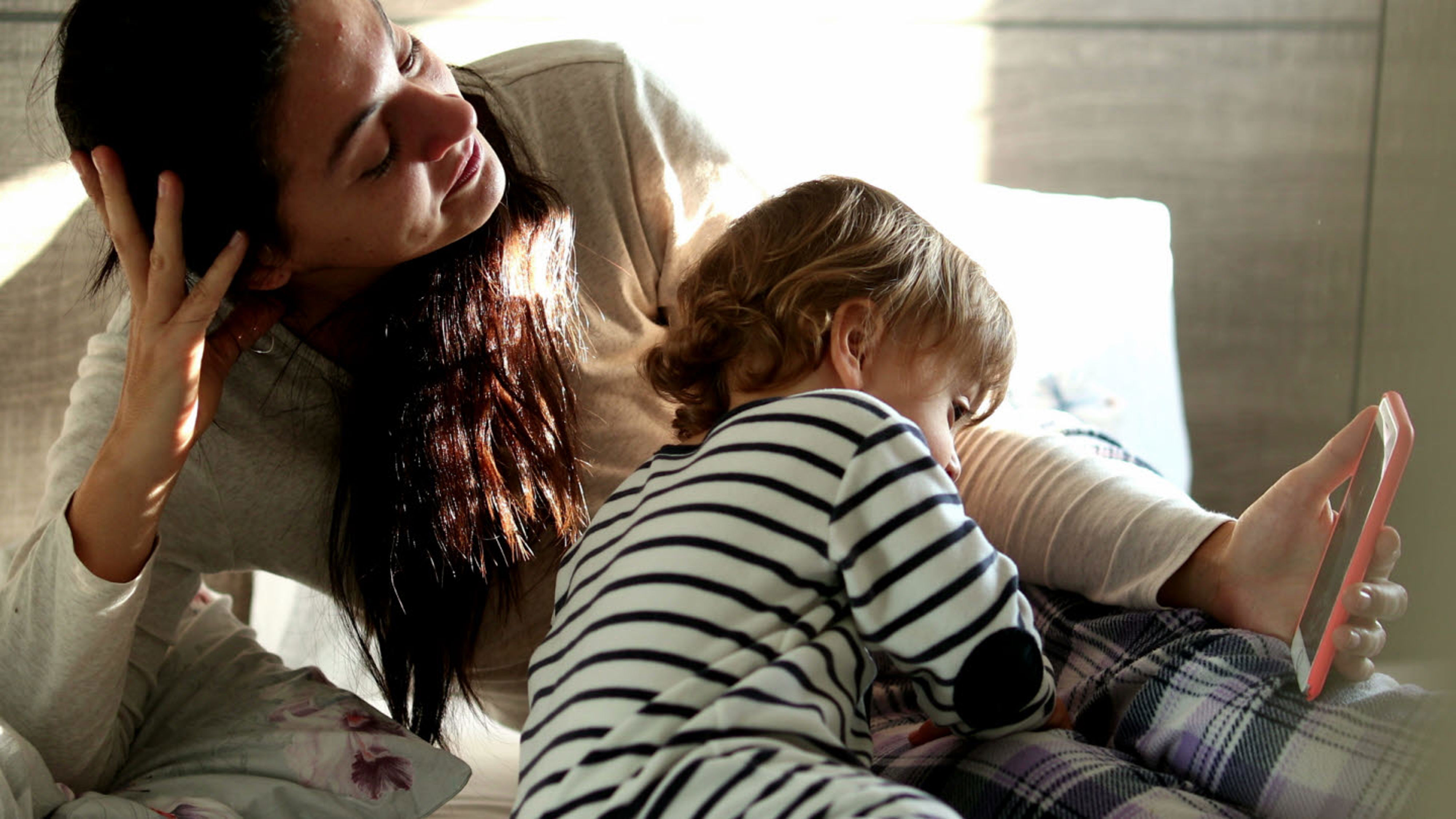 mamma och barn tittar på telefon