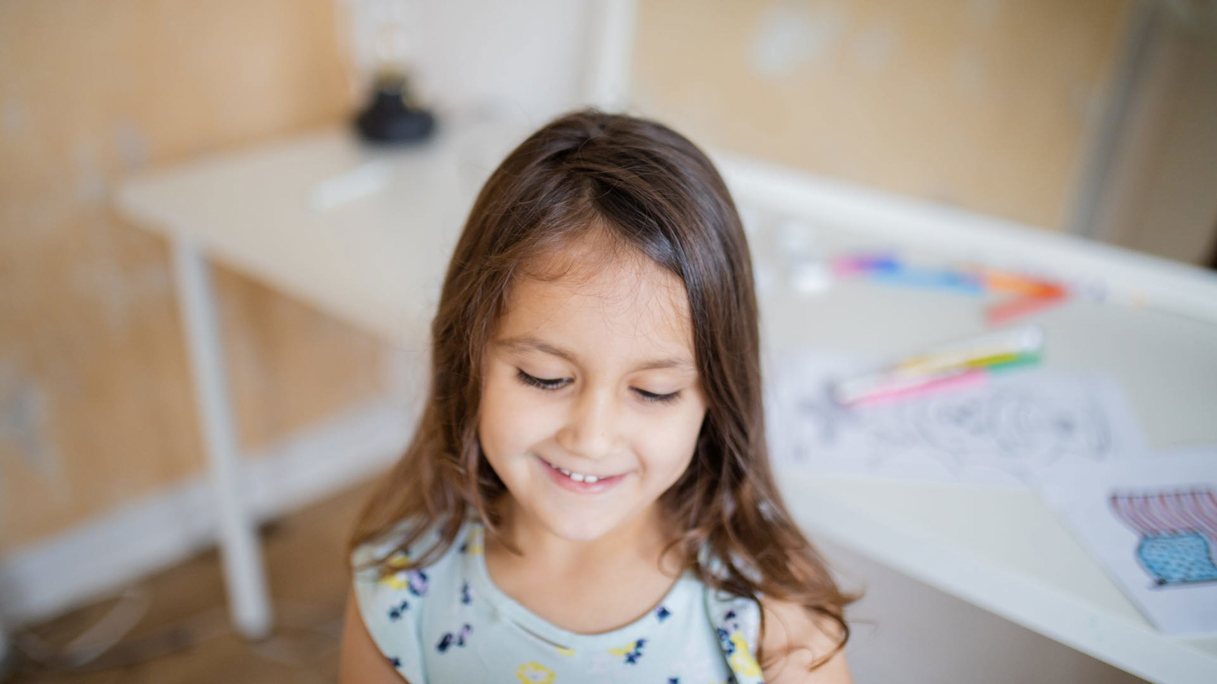 glad flicka vid skrivbord