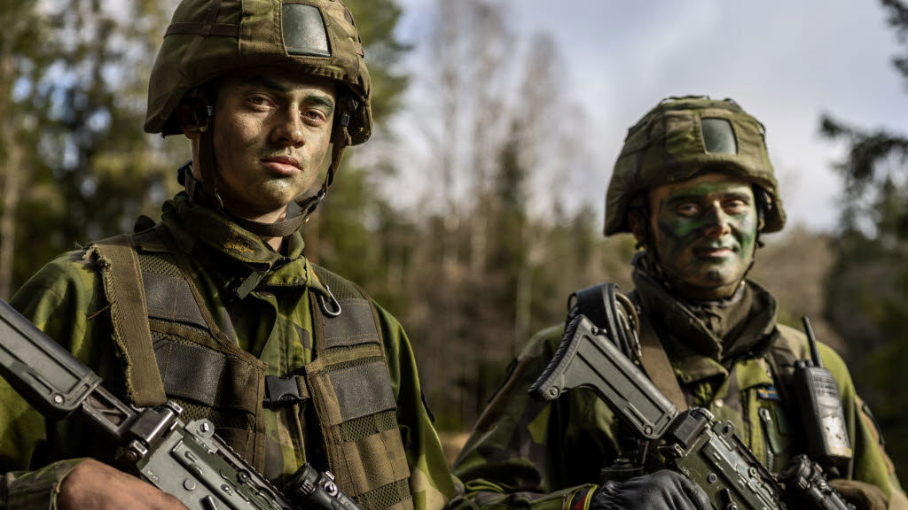Två militära personer tittar in i kameran.