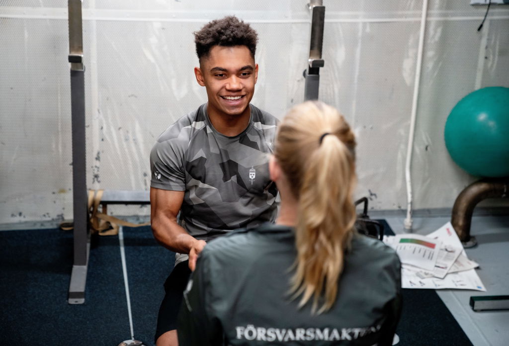 En person med träningskläder ler mot en annan person i träningskläder.