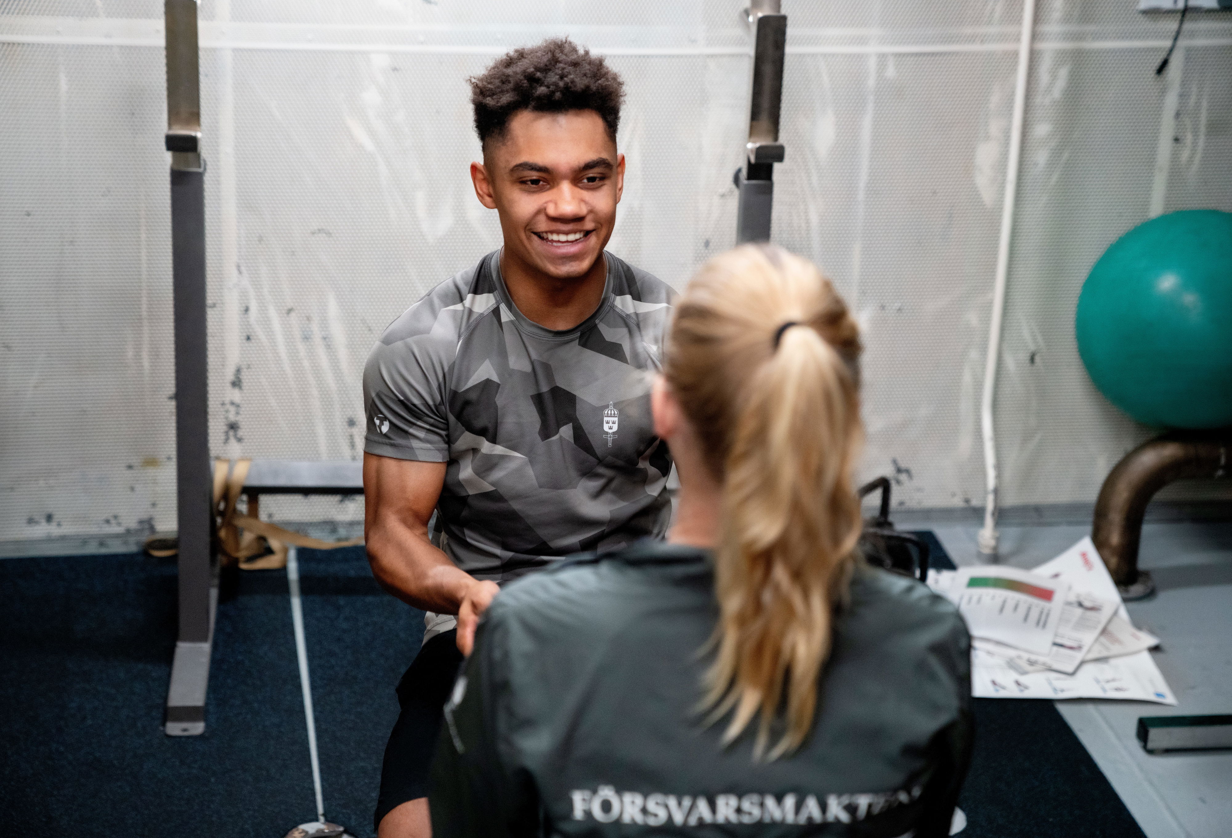 En person med träningskläder ler mot en annan person i träningskläder.